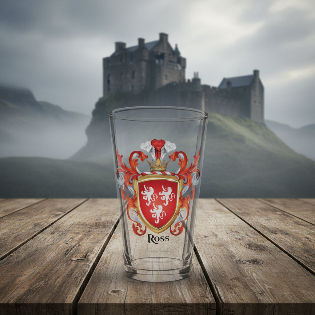 Clear glass with a Ross coat of arms design and 'Ross' in black letters below the red shield which gas 3 white lions on the pint glass. The glass is on a wooden table with a castle in the background.