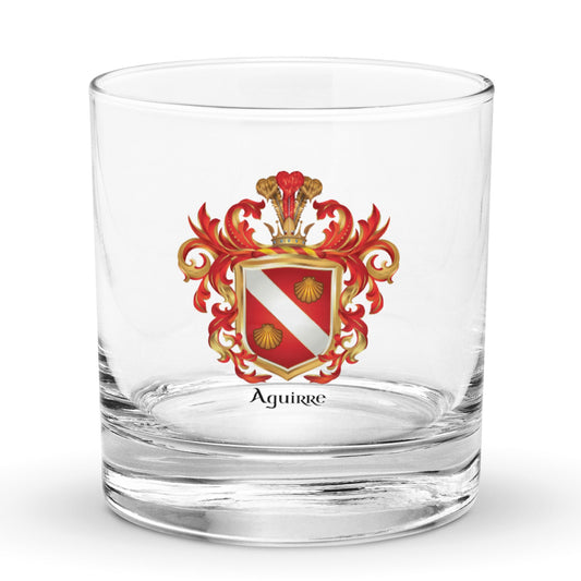 The Aguirre Family Crest on a classic rocks glass featuring a red shield with a white band and 2 gold clam shells - Family Crests Store