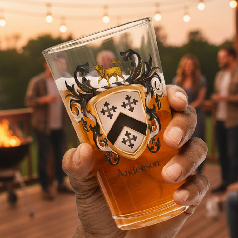 Hand holding a glass of beer with an Anderson Family Crest featuring three black crosses and a black chevron on a white shield with a hound standing on thew crest of the shield