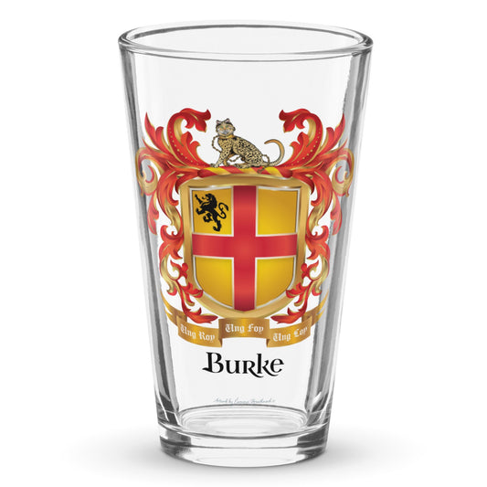 A clear classic pint beer glass on a white background, printed with the Burke Family Crest featuring a gold shield with a red cross.
