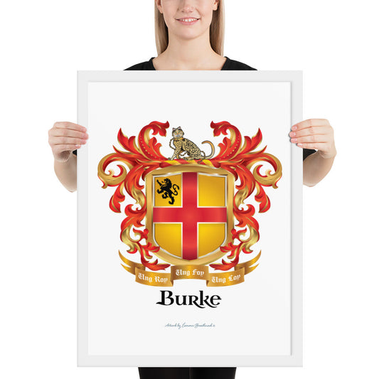 A woman standing in a white background, holding a white framed print of the Burke Family Crest featuring a gold shield with a red cross.