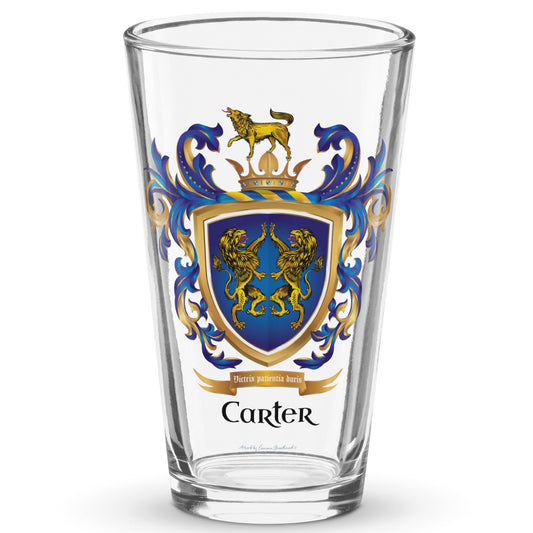 A clear classic pint beer glass on a white background printed with the Carter Family Crest featuring 2 lions on a blue shield and a wolf on a crown on the crest above the shield.