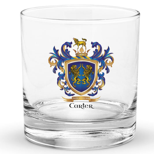 A clear classic heavy base rocks glass on a white background, printed with the Carter Family Crest featuring 2 lions on a blue shield and a wolf on a crown on the crest above the shield.