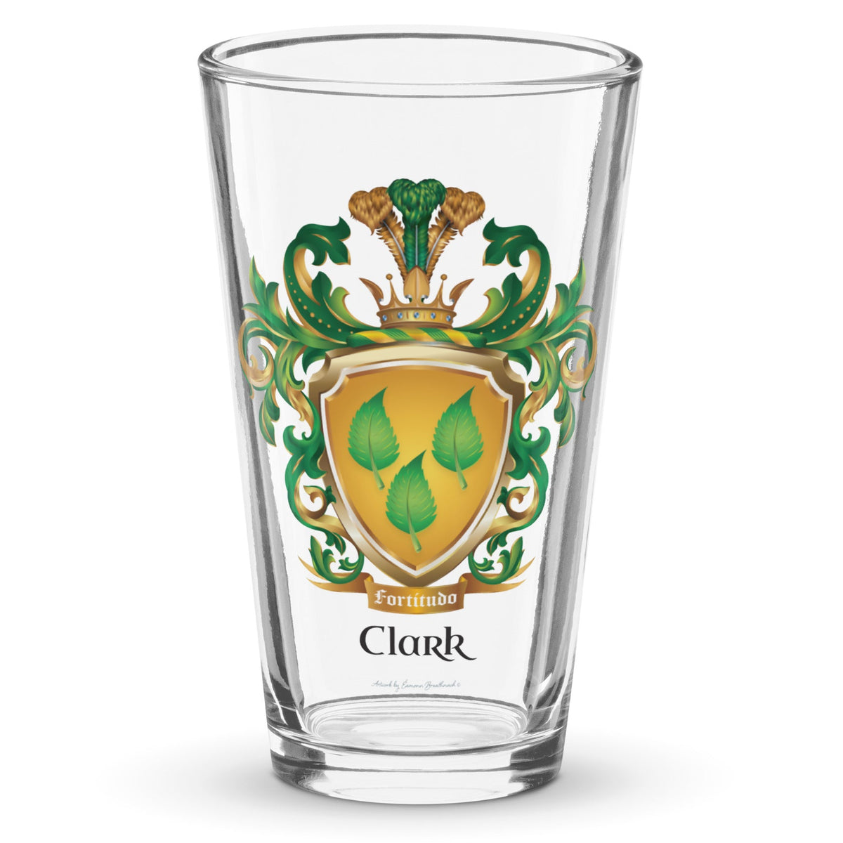A classic clear pint beer glass on a white background with the Clark Family Crest on the front showing a golden shield with 3 green leaves.