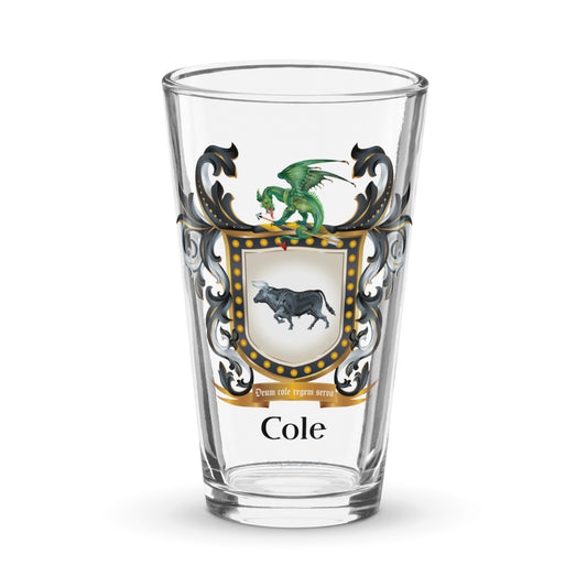 A pint glass against a white background with the Cole family coat of arms showing a black bull and a dragon on the front of the glass 
