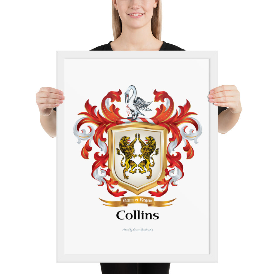 A woman standing in a white background, holding a white framed print of the Collins Family Crest featuring 2 lions on a white shield.