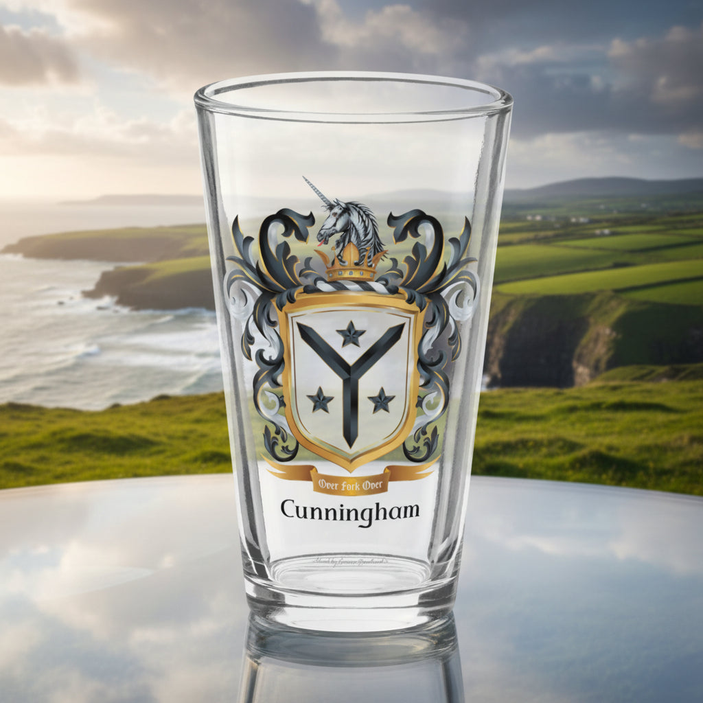 A clear pint glass featuring a printed family crest with a unicorn, black and gold mantling, a shield with three stars, and the name 'Cunningham' printed below, shown on a white background.