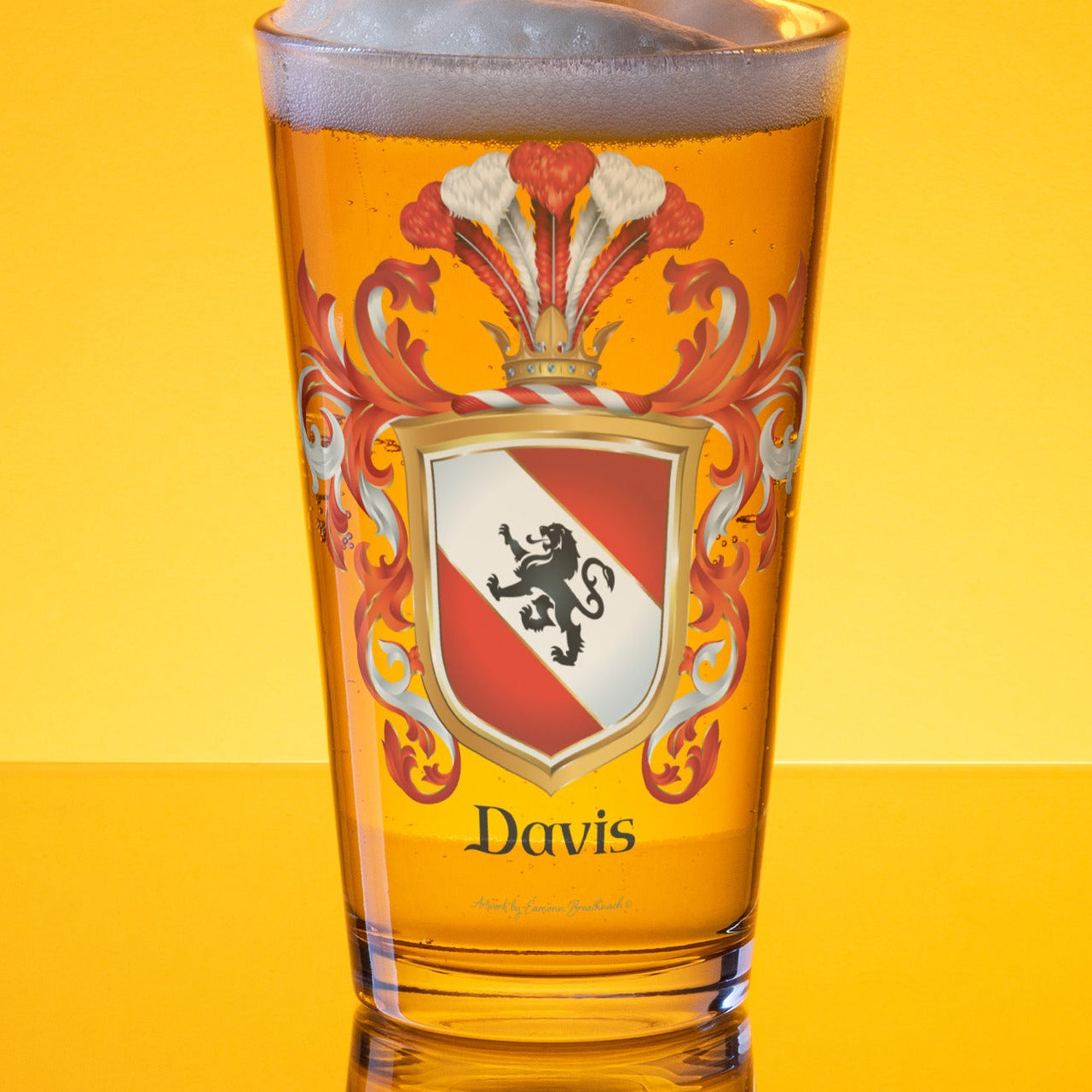 Filled frothy beer glass with a Davis' family crest design 