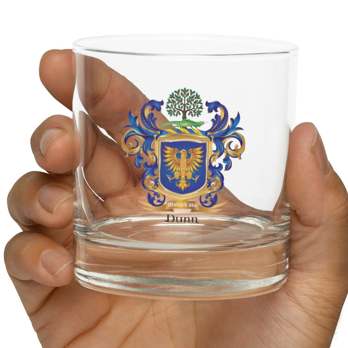 Clear glass with Dunn coat of arms held in a hand on a white background