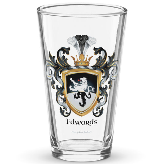 A clear classic pint beer glass on a white background, printed with the Edwards Family Crest which features a lion on a horizontally split black and white shield.