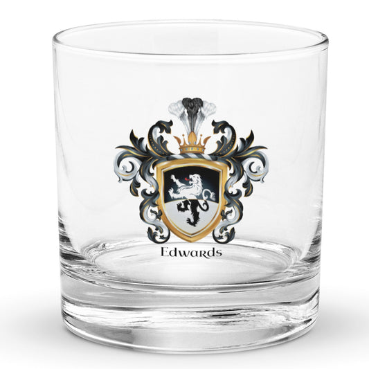A clear classic heavy base rocks glass on a white background, printed with the Edwards Family Crest which features a lion on a horizontally split black and white shield