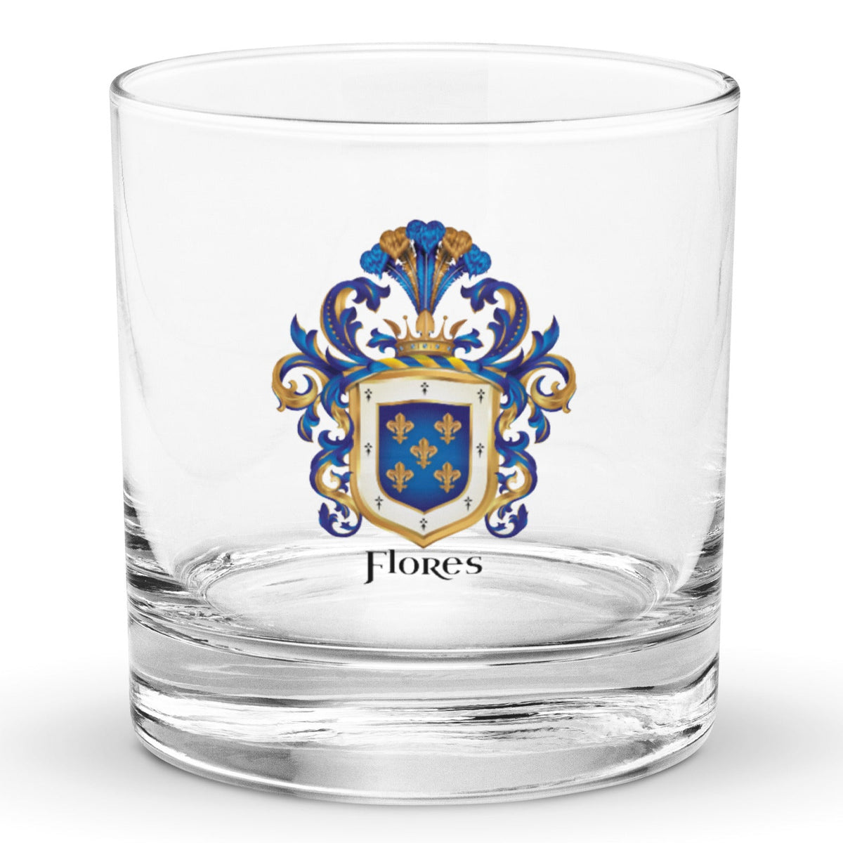 A classic rocks glass on a white background with the Flores Family Crest printed on it. The coat of arms has a blue shield, 5 gold fleur-de-lis, blue and gold mantling, and the name 'Flores' in black heraldic text.