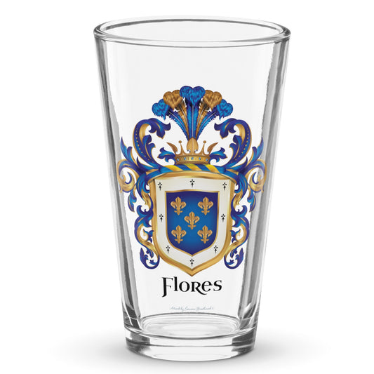 A pint beer glass on a white background with the Flores Family Crest printed on it. The coat of arms has a blue shield, 5 gold fleur-de-lis, blue and gold mantling, and the name 'Flores' in black heraldic text.