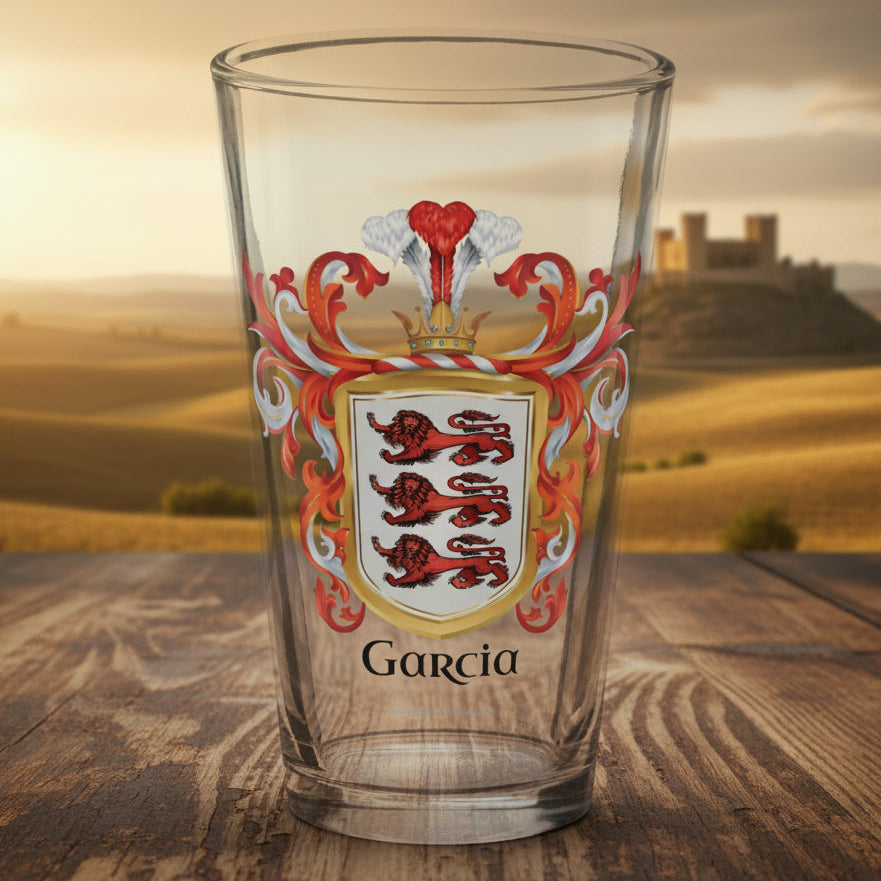 Clear glass with a coat of arms design and 'Garcia' text on wooden table top with a landscape scene of Castile in the background