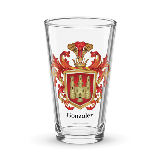 A clear pint glass with the Gonzalez Family Crest featuring a golden castle with 3 towers on a red shield pictured on a white backgroud