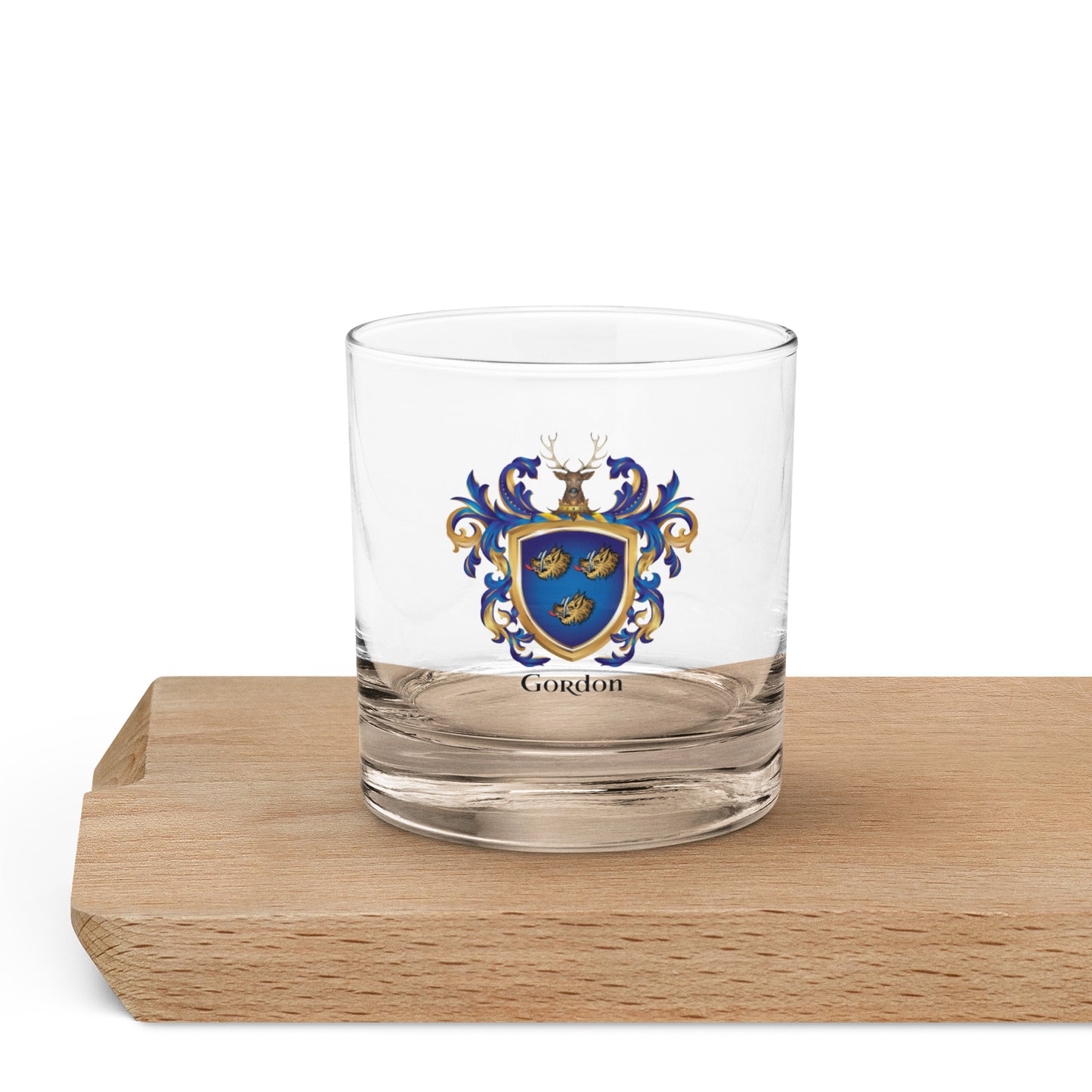 Gordon-Family-Crest on a rocks glass placed on a wooden serving board
