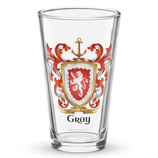 A clear classic pint beer glass on a white background, printed with the Gray Family Crest featuring a red shield and white lion and a gold anchor on the crest.