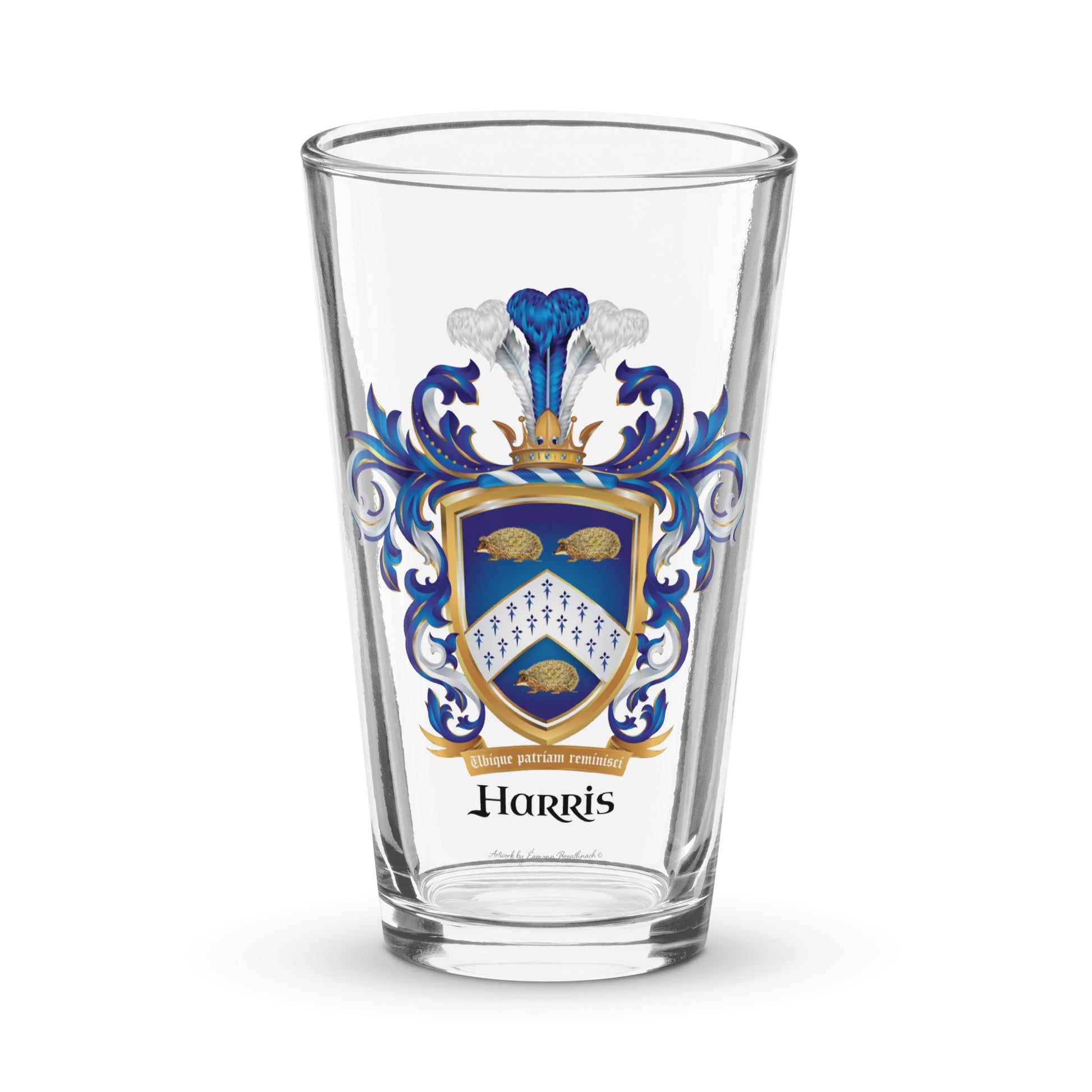 A clear pint beer glass with the Harris Family Crest on the front featuring 3 hedgehogs on a blue shield with a white chevron containing an ermine pattern pictured against a white background.