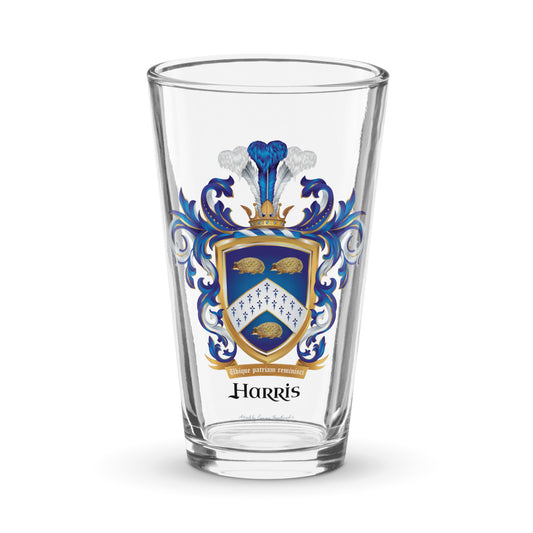 A clear pint beer glass with the Harris Family Crest on the front featuring 3 hedgehogs on a blue shield with a white chevron containing an ermine pattern pictured against a white background.