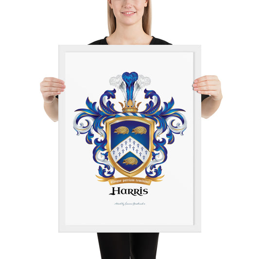 A woman standing up holding a white framed print of the Harris Family Crest featuring 3 hedgehogs.