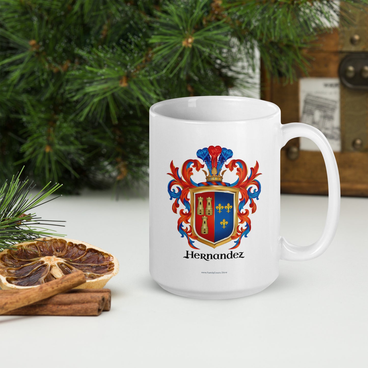 White mug with a colorful coat of arms design and 'Hernandez' text, placed beside Christmas decorations.