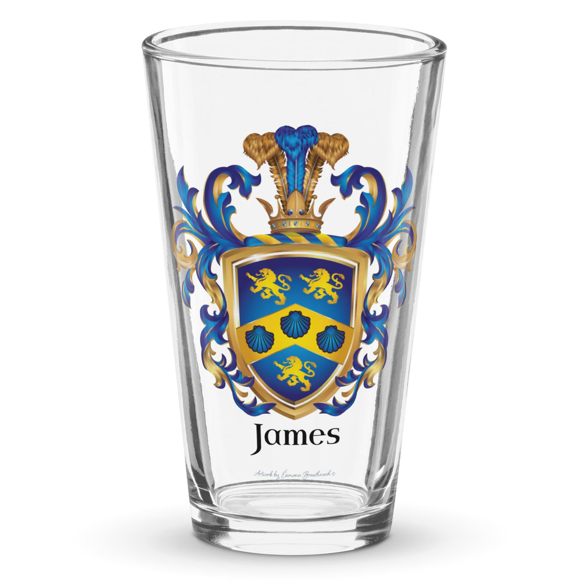 A clear classic pint beer glass on a white background, printed with the James Family Crest which features a blue shield with a golden chevron containing 3 blue clam shells and two gold lions above the chevron and one beneath it.