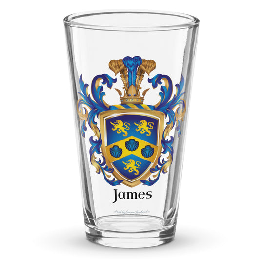 A clear classic pint beer glass on a white background, printed with the James Family Crest which features a blue shield with a golden chevron containing 3 blue clam shells and two gold lions above the chevron and one beneath it.
