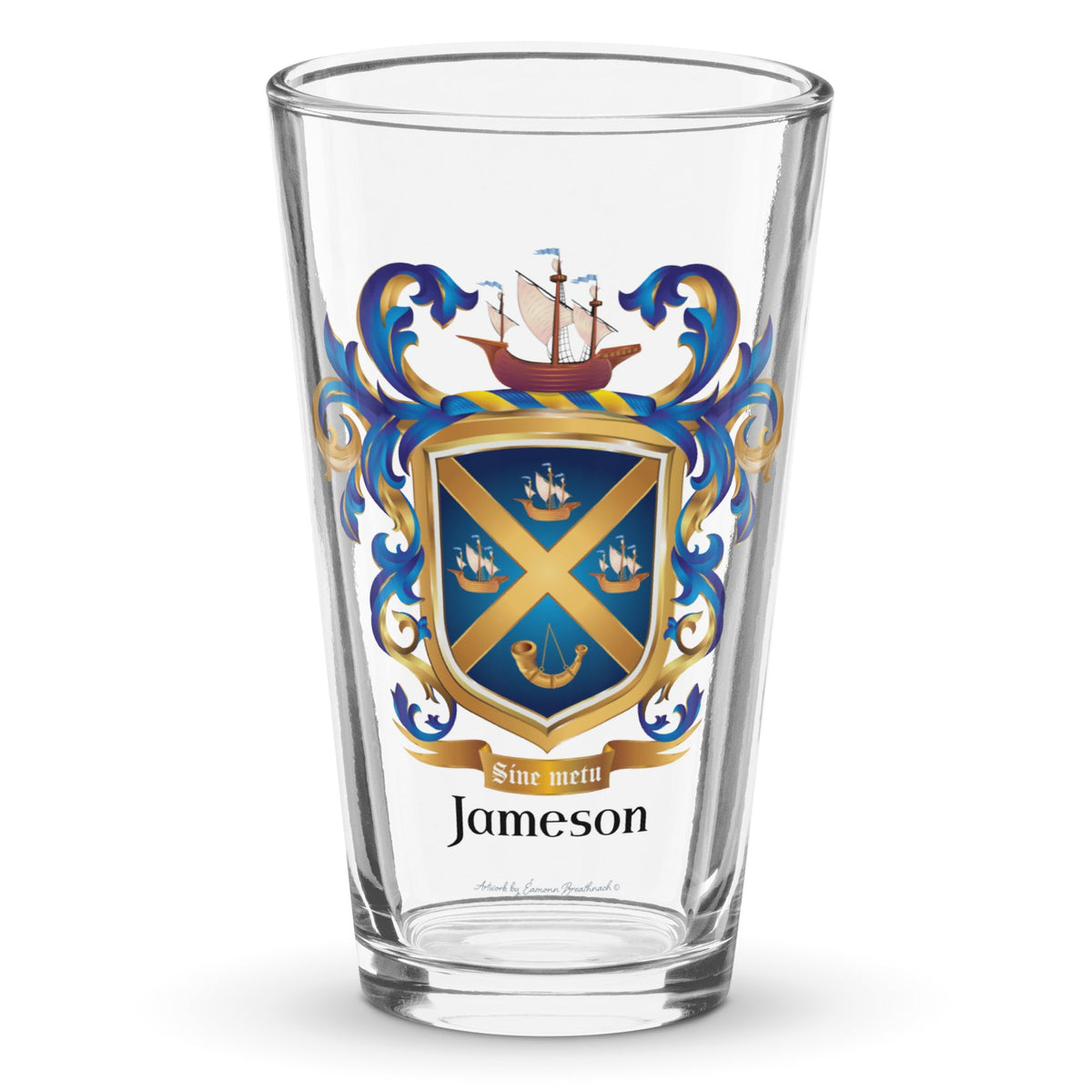A clear classic pint beer glass on a white background, printed with the Jameson Family Crest featuring a blue shield with a gols diagonal cross, 3 ships and a horn.