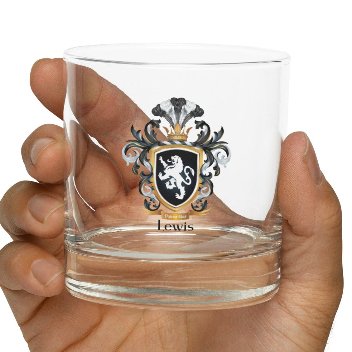 Rocks glass with a Lewis-Family-Crests with white lion on black shield in a hand against a white background