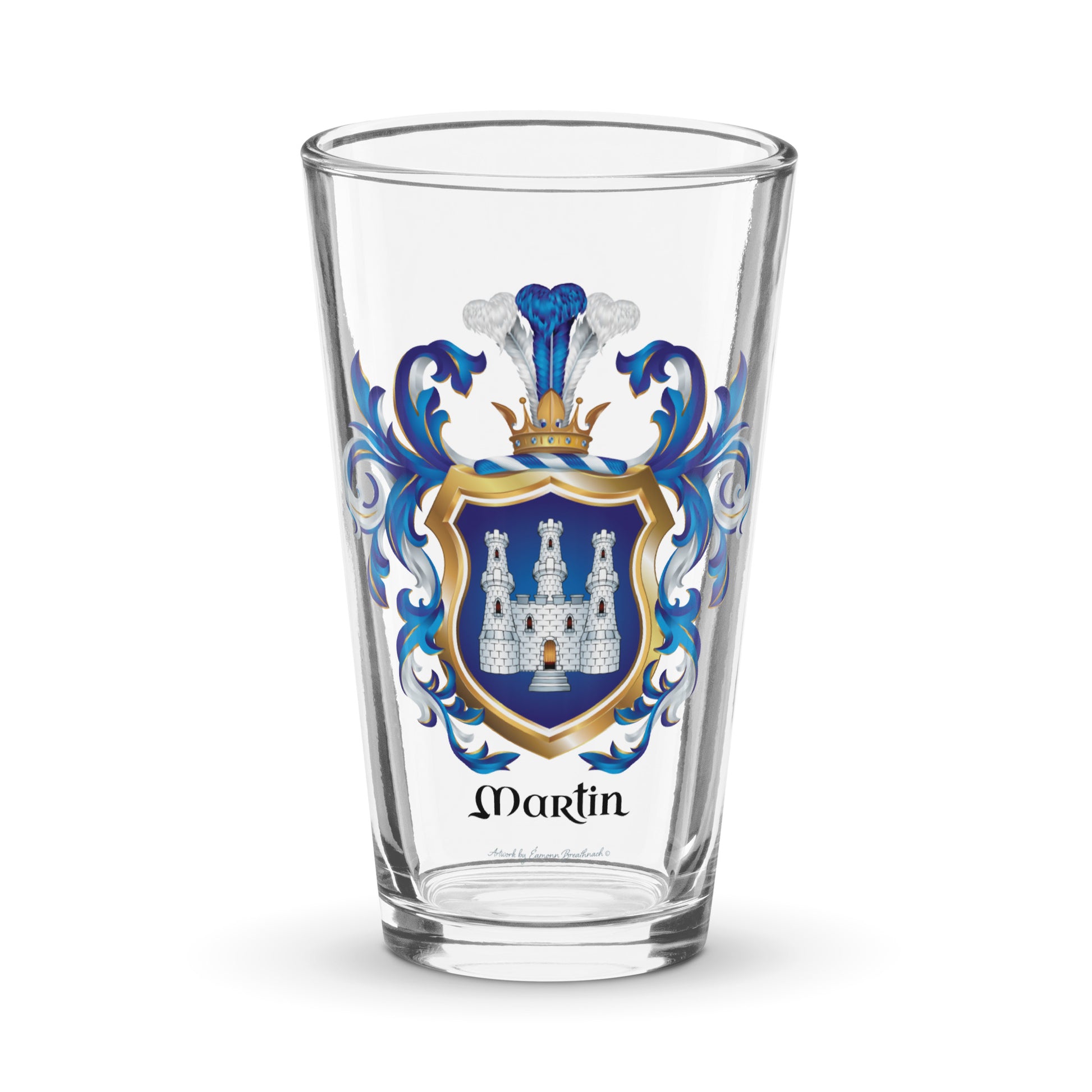 A clear pint glass featuring a personalized family crest with the name 'Martin' printed below. The crest includes a blue and gold shield with a white castle, flanked by blue mantling,