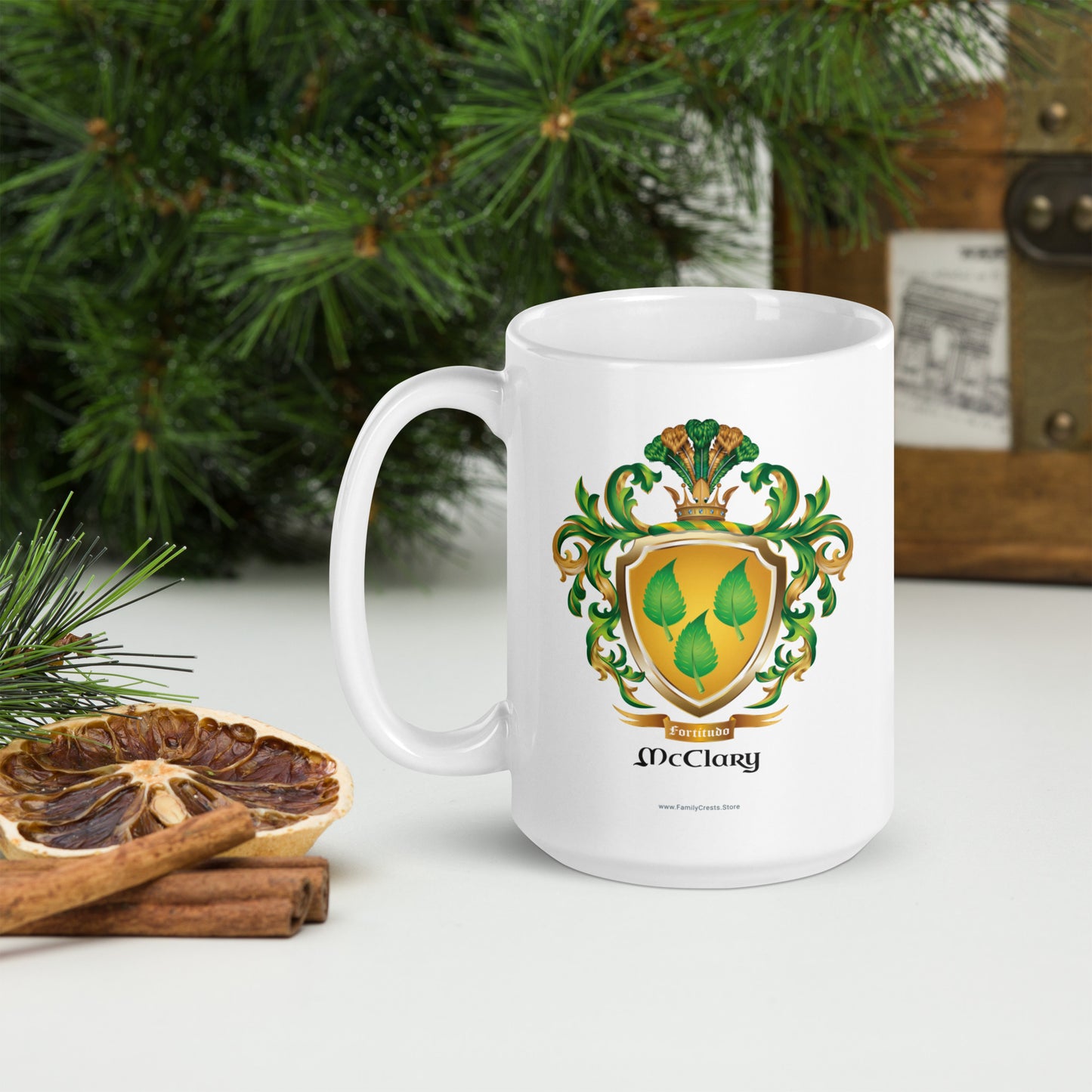 McClary family name coat of arms white mug with a family crest design featuring leaves and the name 'McClary' on a table with decorative items.