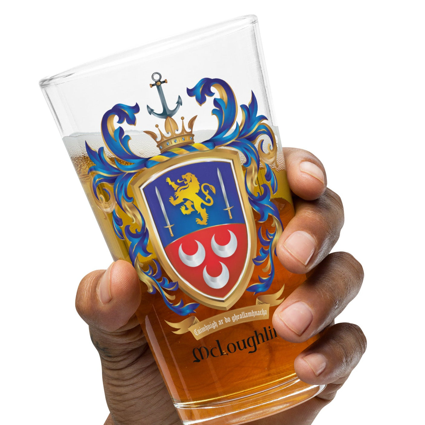 A hand holding a clear pint glass with a colorful heraldic crest and the name 'McLoughlin' printed near the base, filled with amber beer, against a plain white background.