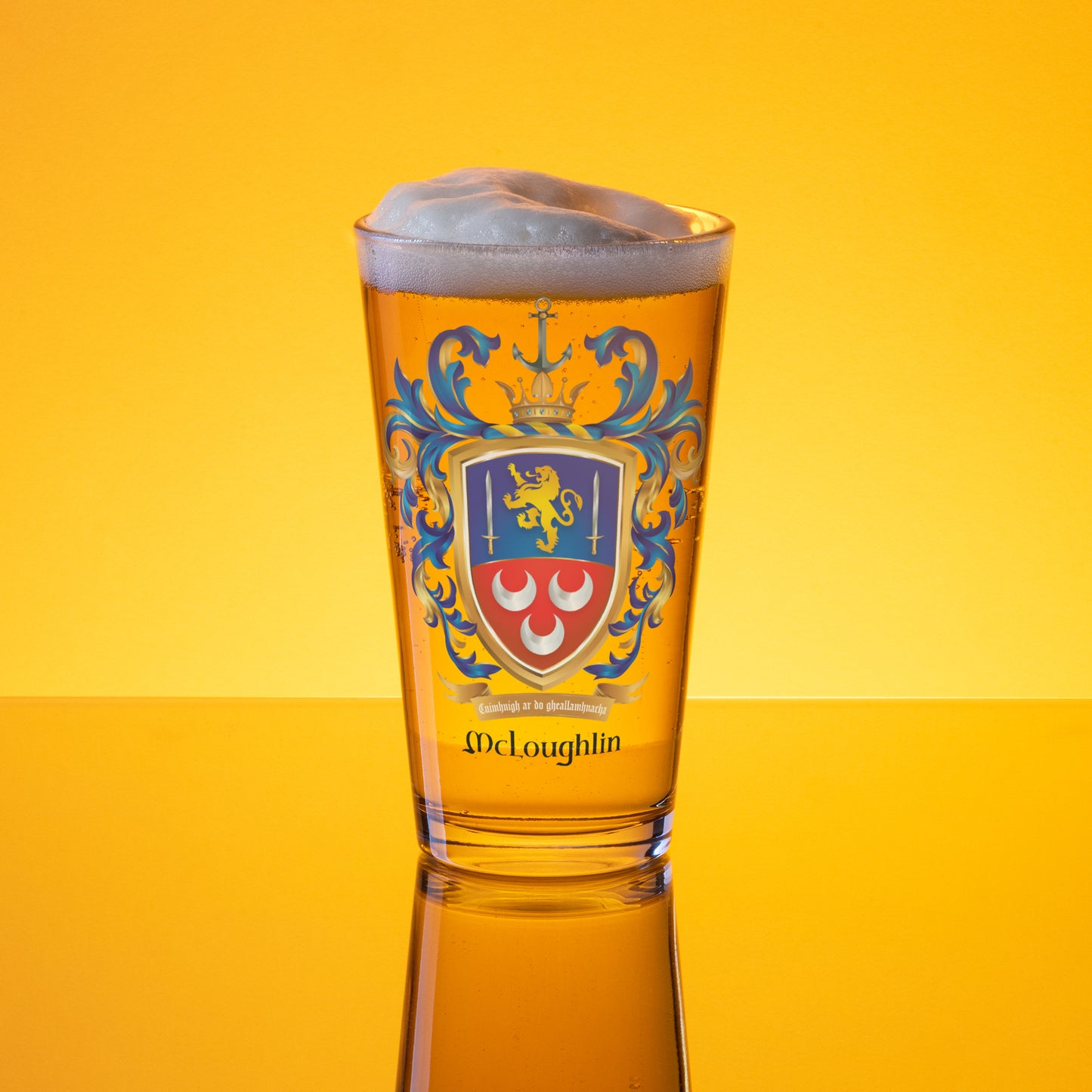 A clear pint glass filled with golden beer, topped with white foam, featuring a blue and red McLoughlin crest design on the front, set against a bright yellow gradient background.