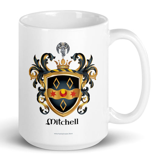 A white mug on a white background, printed with the Mitchell Family Crest featuring a black shield witha wavy gold ribbon with 2 red stars and a red cresent and 3 gold diamonds and an angel holding a dove above the shield on the crest.