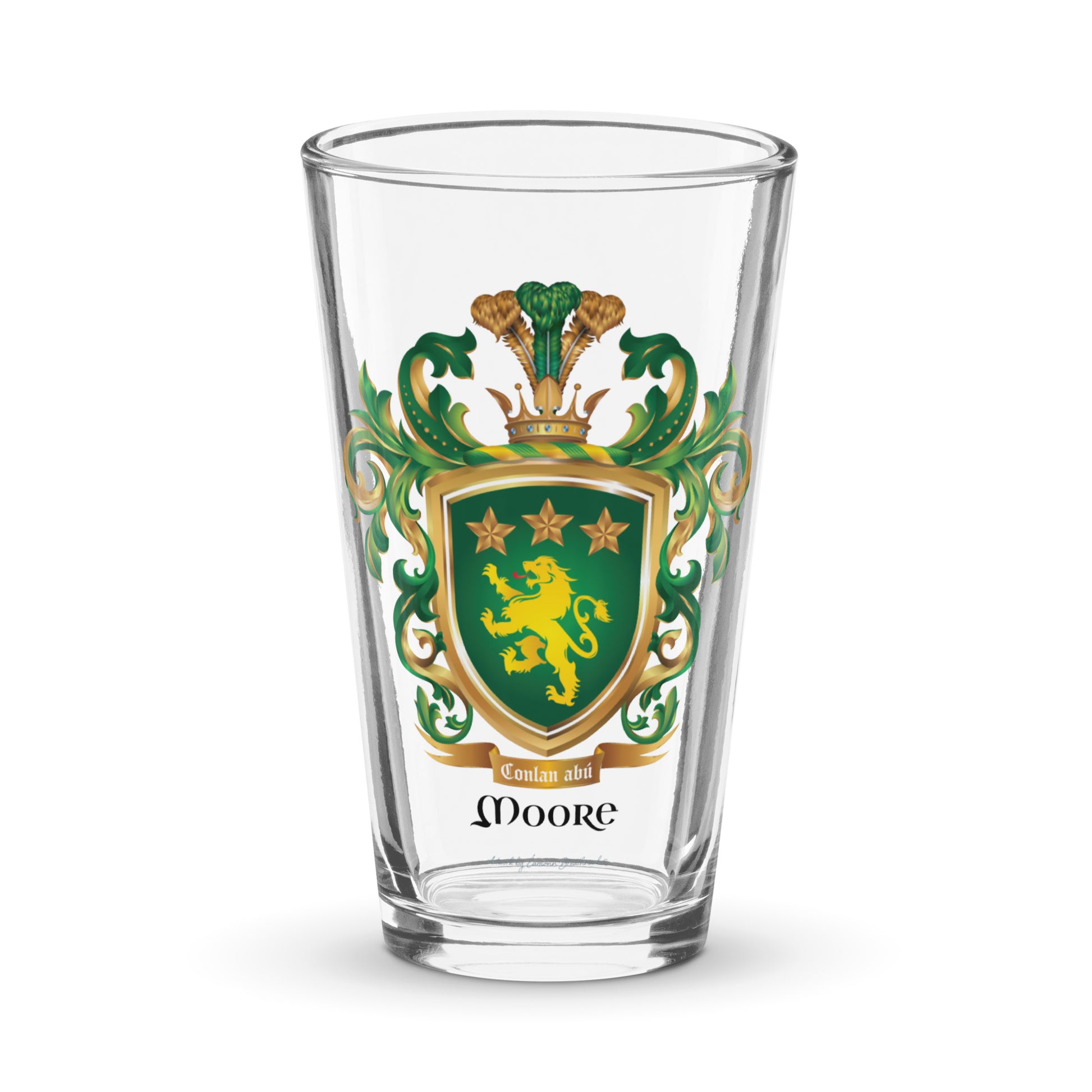 Clear pint beer glass featuring The Moore Family Crest showing a green shield with a gold lion and three gold stars above the lion with the motto and Moore name beloe the shield and a crown above and green and gold mantling all around  on a white background