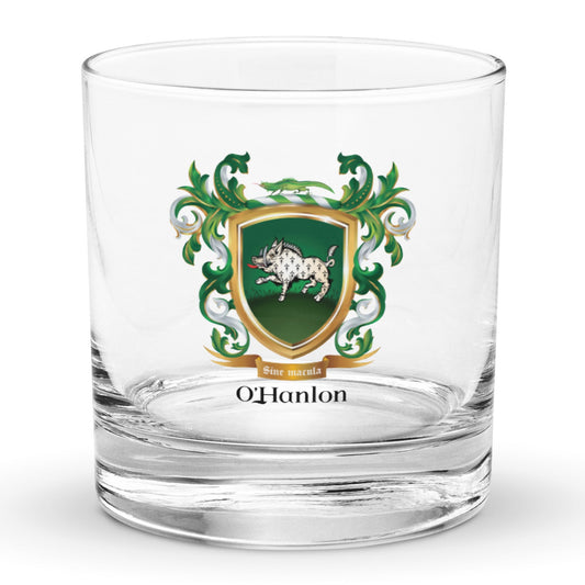 A classic heavy base rocks glass on a white background with the O'Hanlon Family Crest featuring a white boar with ermine pattern on a green shield