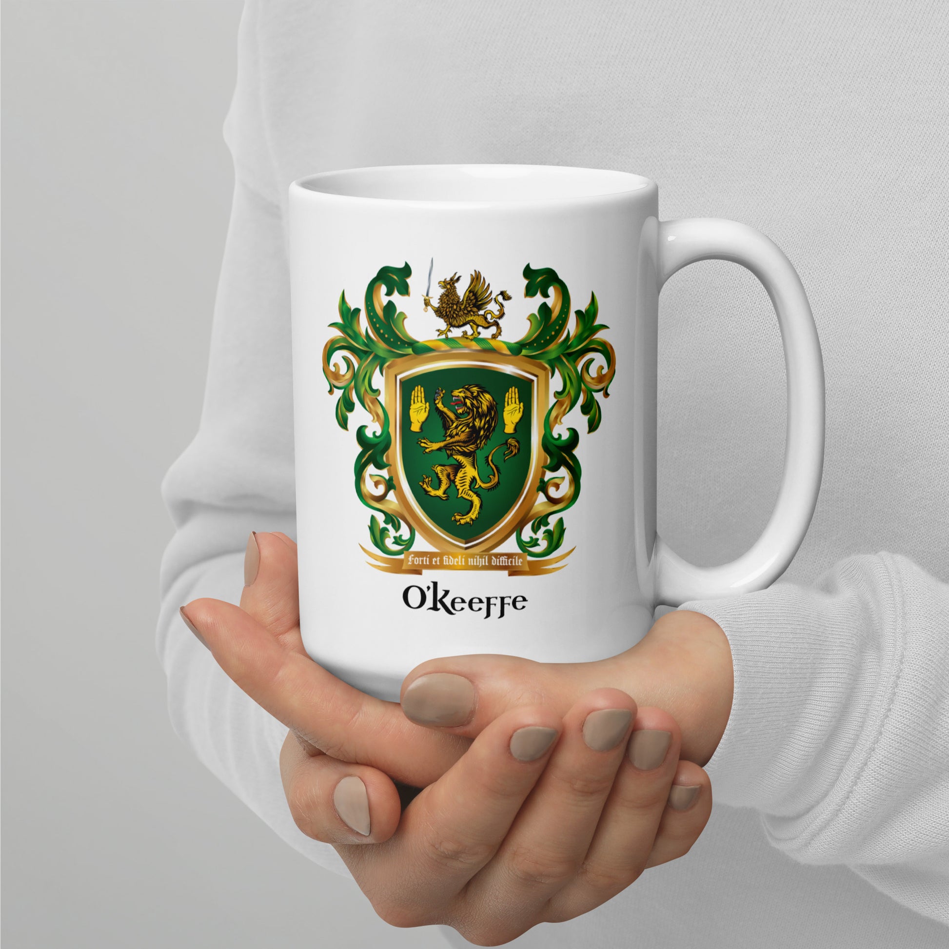 O’Keeffe Family Crest white mug with a green and gold crest and 'O'Keeffe' text and detailed lion and griffin