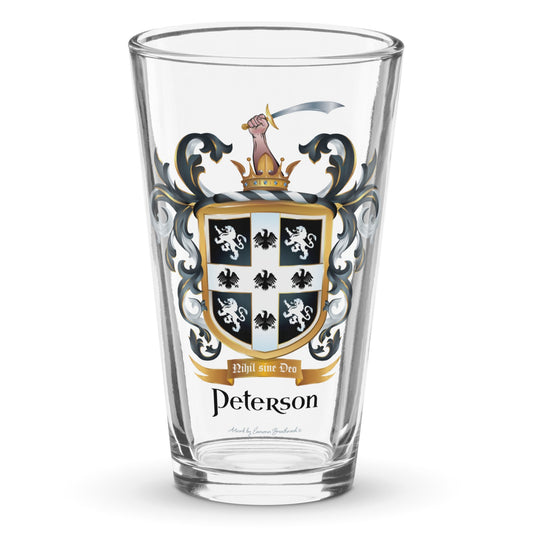 A clear classic pint beer glass on a white background, printed with the Peterson Family Crest featuring 4 lions and 5 eagles on a black shield.