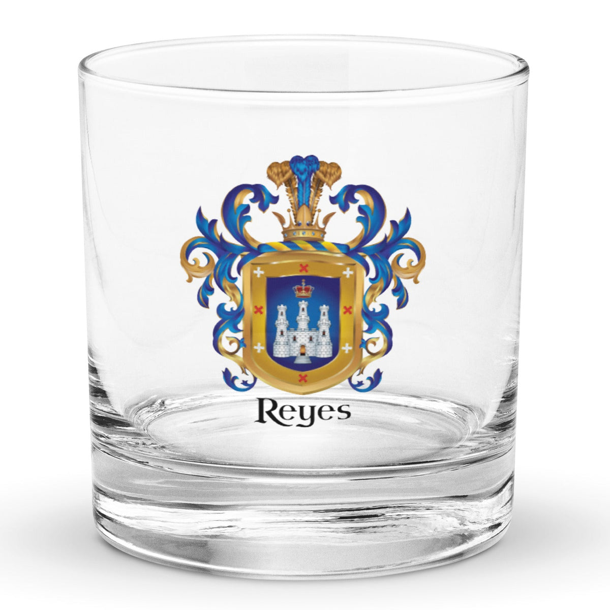 A clear classic heavy base rocks glass on a white background, printed with the Reyes Family Crest which features a blue shield with a white castle and crown.