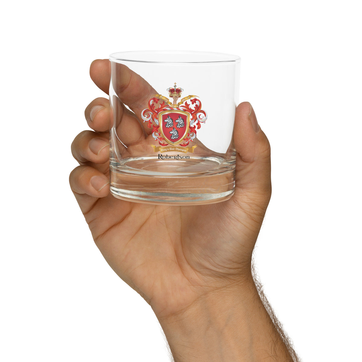 Hand holding a clear glass with a Robertson Family Crest oat of arms design on a white background
