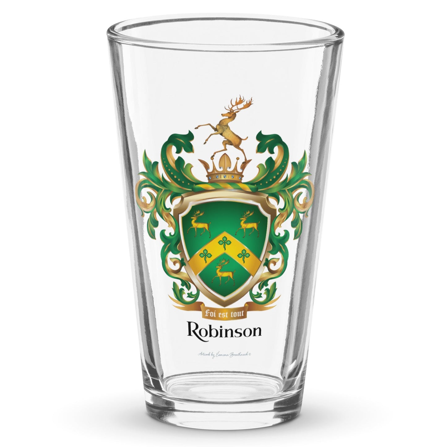 A clear pint glass with the Robinson-Family-Crest print on the front of the glass featuring a green shield with three gold stags, a golden chevron with 3 shamrocks and above the shield a stag standing on a gold crown and below the shield a motto and the name Robinson in black letters.