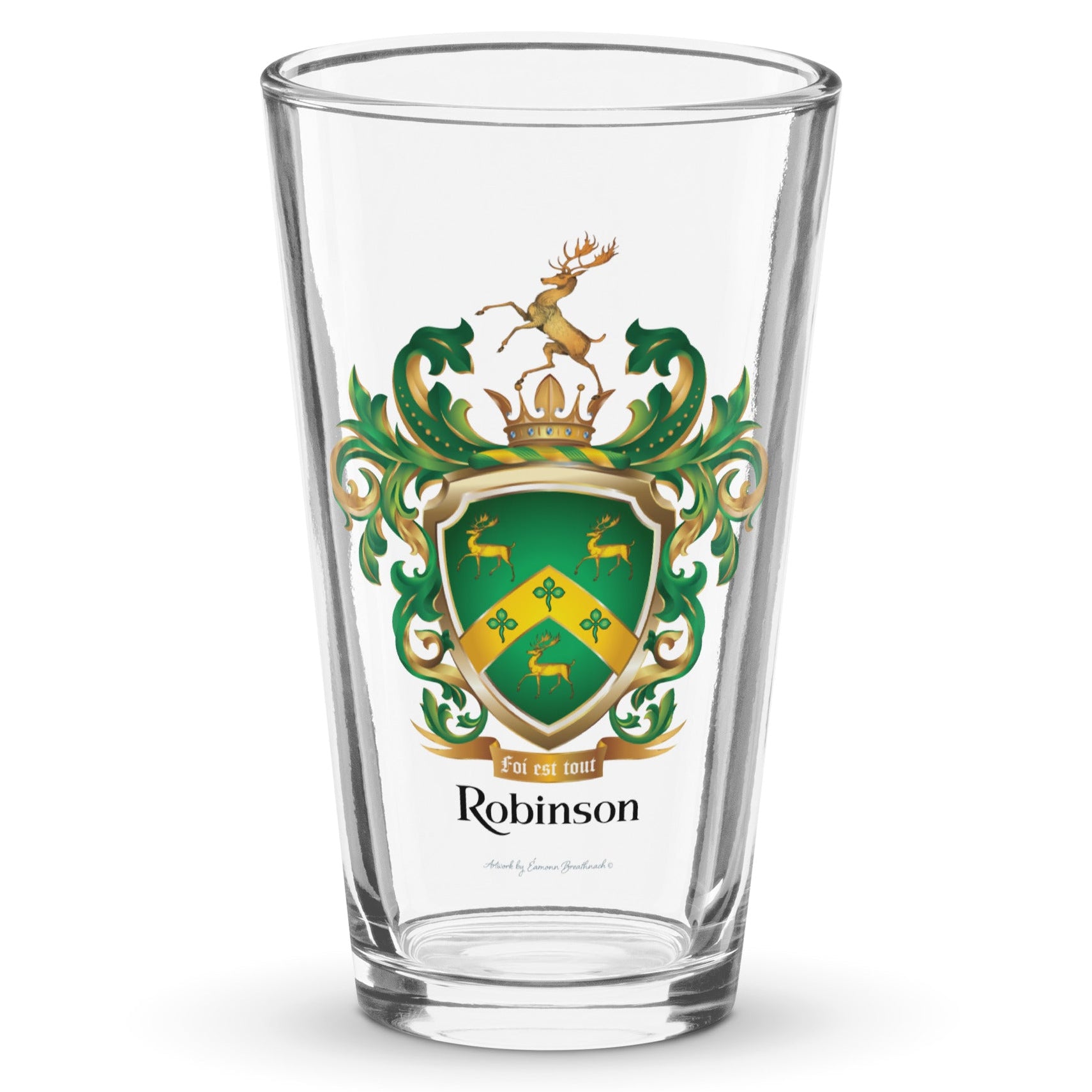 A clear pint glass with the Robinson-Family-Crest print on the front of the glass featuring a green shield with three gold stags, a golden chevron with 3 shamrocks and above the shield a stag standing on a gold crown and below the shield a motto and the name Robinson in black letters.