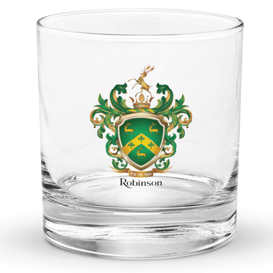 Rocks glass with the Robinson-Family-Crest print on the front of the glass featuring a green shield with three gold stags, a golden chevron with 3 shamrocks and above the shield a stag standing on a gold crown and below the shield a motto and the name Robinson in black letters.