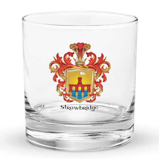 A rocks glass on a white background with a Strawbridge family crest featuring a red bridge on a golden shield