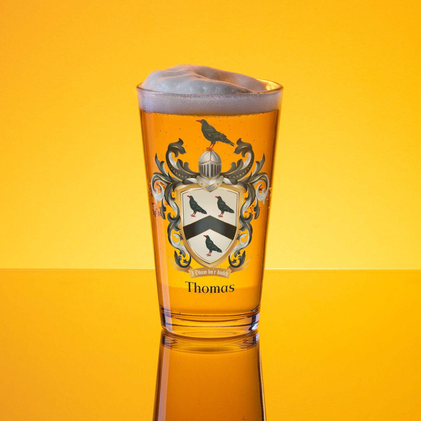 Glass of beer with a Thomas Family Crest design on a yellow background