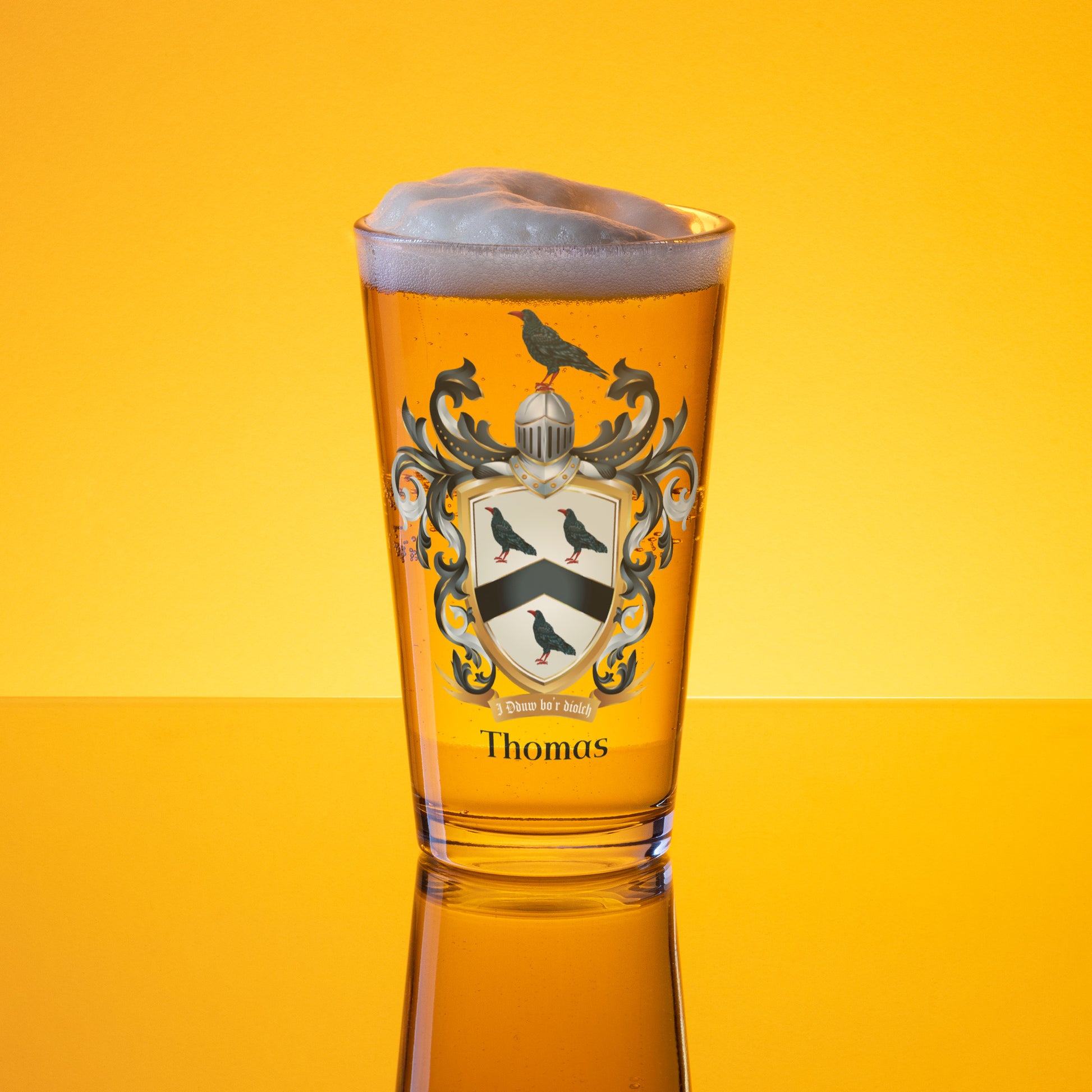 Glass of beer with a Thomas Family Crest design on a yellow background