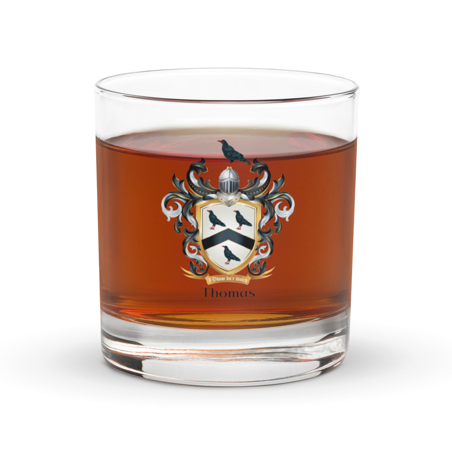 Glass of whiskey with a Thomas family crest emblem on a white background