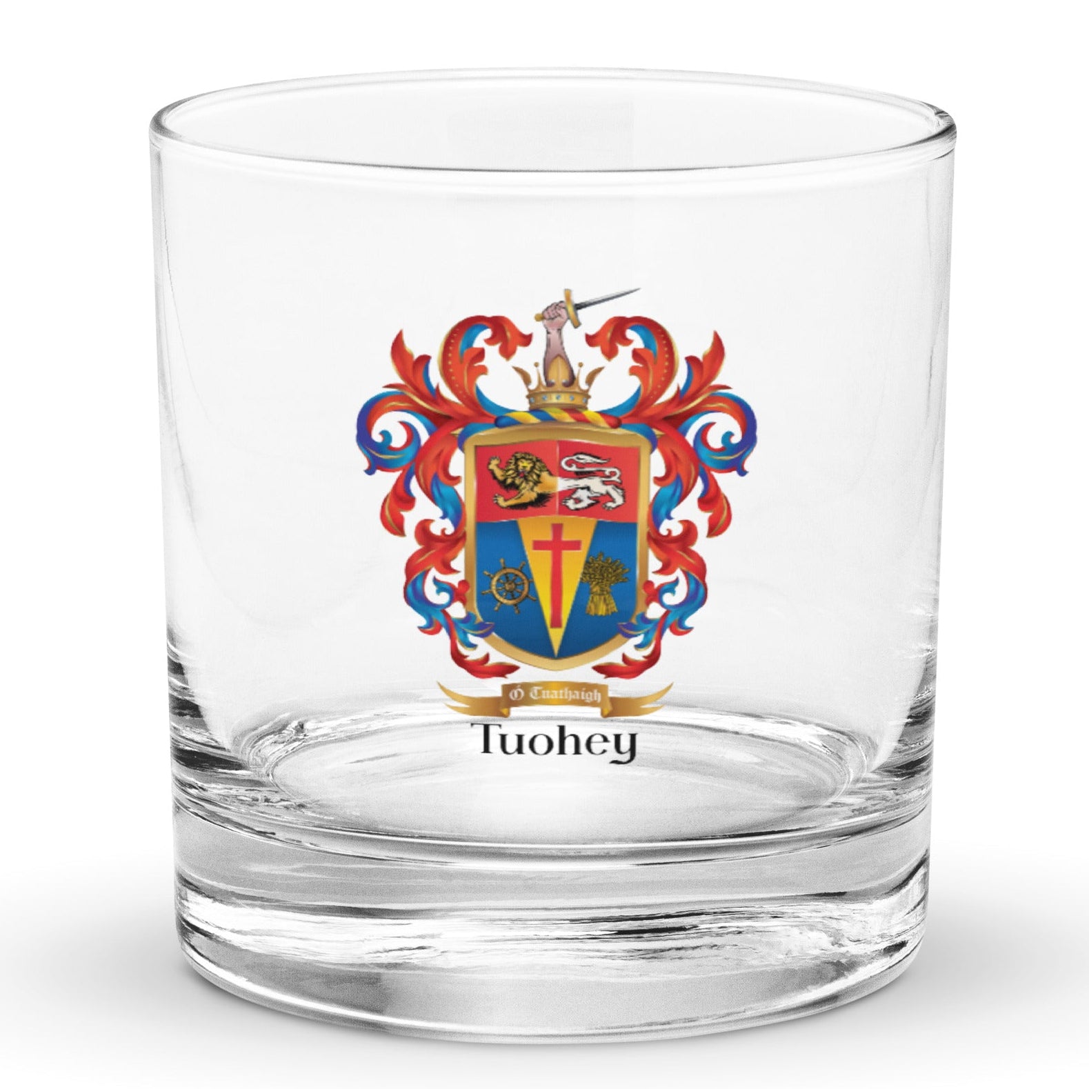 A classic rocks glass on a white background ith a Tuohey_Family_Crest_on the front of the glass featring a lion and a cross.