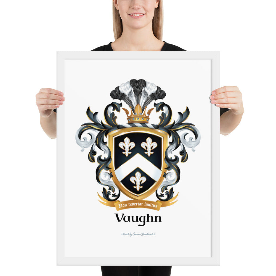 A woman standing in a white background, holding a white framed print of the Vaughn Family Crest featuring a black shield with a white chevron and 3 white fleur de lis.