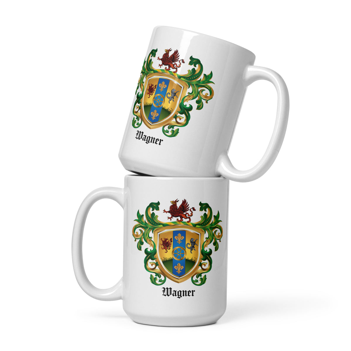 Two stacked white ceramic mugs with a detailed family crest printed on the front, featuring the name 'Wagner' below. The crest includes a shield with blue, yellow, and red sections, green mantling, set against a clean white background.